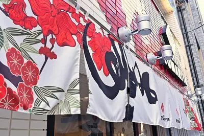 a banner on the side of a building with flowers on it at Hotel Tomariya Ueno in Tokyo