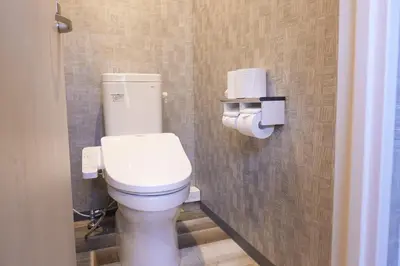 a bathroom with a white toilet in a stall at Hotel Tomariya Ueno in Tokyo