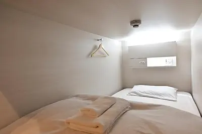 a room with a bed with a towel on it at Hotel Tomariya Ueno in Tokyo