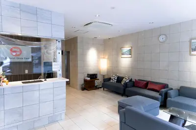a waiting room with two blue couches and a table at ELE Hotel Ginza East in Tokyo