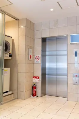 a metal elevator in a building with a fire extinguisher at ELE Hotel Ginza East in Tokyo