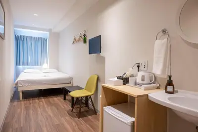 a bathroom with a sink and a bed in a room at ELE Hotel Ginza East in Tokyo