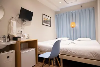a hotel room with two beds and a sink at ELE Hotel Ginza East in Tokyo