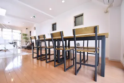 a room with a row of wooden tables and chairs at TERRACE HOUSE Shibuya Maruyamacho in Tokyo