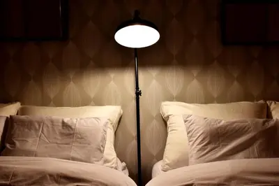 a lamp sitting next to two beds in a room at TERRACE HOUSE Shibuya Maruyamacho in Tokyo