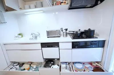 a kitchen with white cabinets and a stove with pots and pans at Skytree House In Tokyo in Tokyo