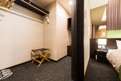 a small room with a bed and a desk and a room with a bed at Super Hotel Premier Tokyo Station Yaesu-Chuoguchi in Tokyo