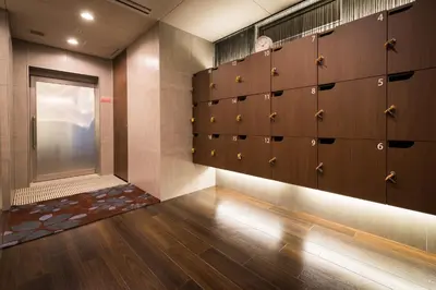 a locker room with wooden lockers and a door at Super Hotel Premier Tokyo Station Yaesu-Chuoguchi in Tokyo