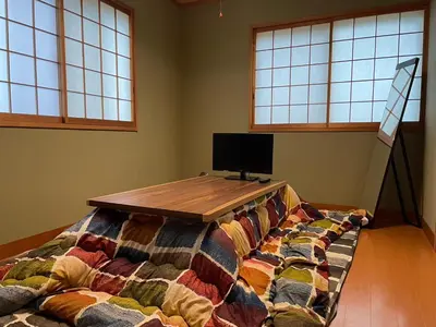 a bed with a wooden table in a room with windows at Ryokan ASAKUSA-chaka- by Tranova in Tokyo