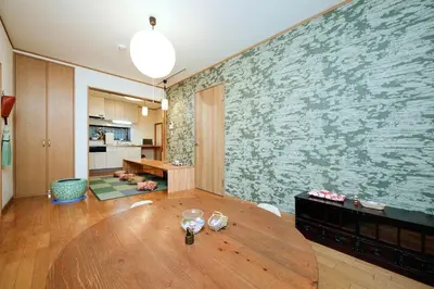 a living room with a table and a large wall mural at Ryokan ASAKUSA-chaka- by Tranova in Tokyo