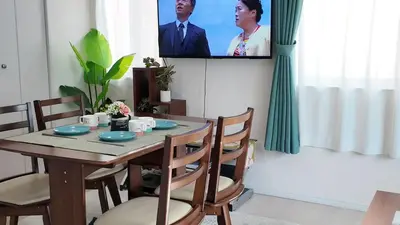 a dining room with a table and a tv at First sight hut house in Tokyo