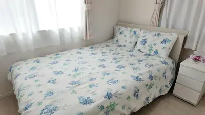 a bedroom with a bed with blue flowers on it at First sight hut house in Tokyo