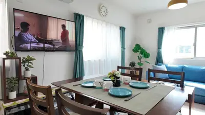 a living room with a table and a tv on the wall at First sight hut house in Tokyo
