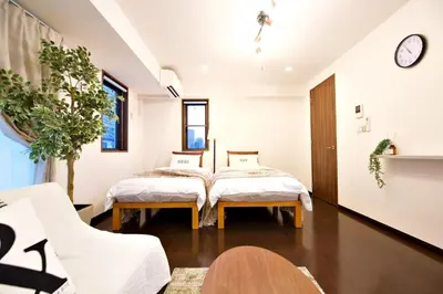 two beds in a room with a table and chairs at Kanbe Building 301 in Tokyo