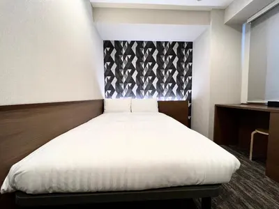 a bedroom with a white bed with a black headboard at KIN HOTEL in Tokyo