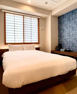 a bedroom with a large white bed and a window at KIN HOTEL in Tokyo