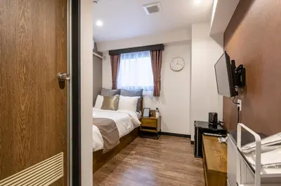 a bedroom with a bed and a clock on the wall at The Park Hotel Akihabara in Tokyo