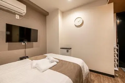 a bedroom with a bed and a clock on the wall at The Park Hotel Akihabara in Tokyo
