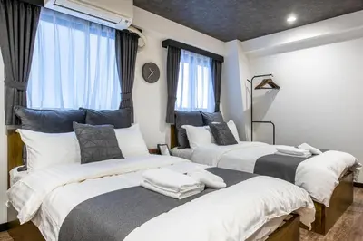 two beds in a room with windows at The Park Hotel Akihabara in Tokyo