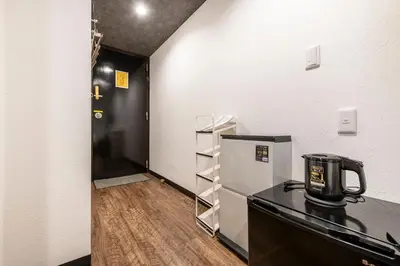 a kitchen with a black counter and a refrigerator at The Park Hotel Akihabara in Tokyo