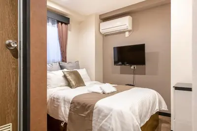 a hotel room with a bed and a flat screen tv at The Park Hotel Akihabara in Tokyo