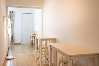 a row of tables and stools in a room at H2O Stay Ikebukuro in Tokyo