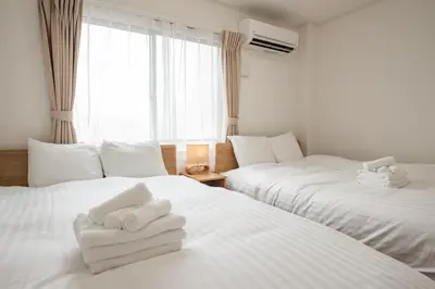 a hotel room with two beds with towels on them at H2O Stay Ikebukuro in Tokyo
