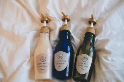 three bottles of wine sitting on top of a bed at H2O Stay Ikebukuro in Tokyo