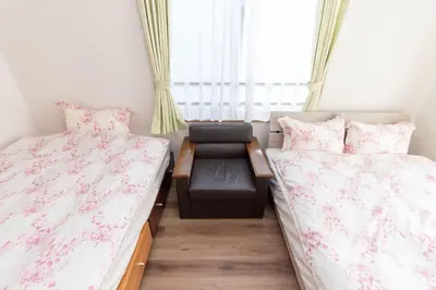 a small room with two beds and a bench between them at Mori House In \u897f\u65e5\u66ae\u91ccI in Tokyo