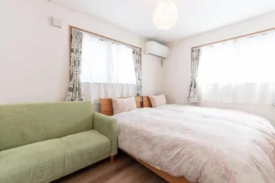 a bedroom with a bed and a couch and a window at Mori House In \u897f\u65e5\u66ae\u91ccI in Tokyo