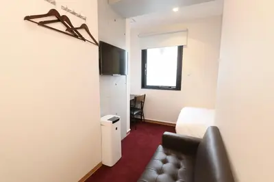 a hotel room with a bed and a couch at Capsule Room Lightning Hotel Asakusa in Tokyo