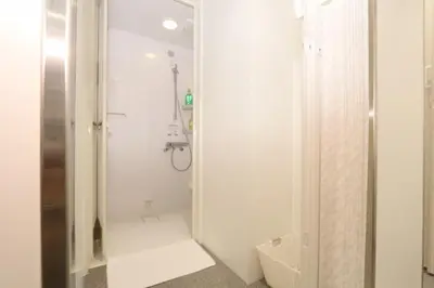 a white bathroom with a shower and a sink at Capsule Room Lightning Hotel Asakusa in Tokyo