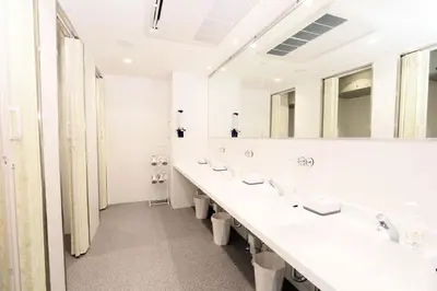 a bathroom with four sinks and a large mirror at Capsule Room Lightning Hotel Asakusa in Tokyo