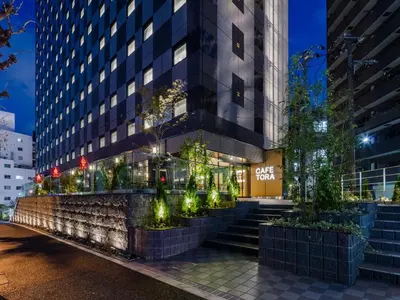 a building with stairs and trees in front of it at APA Hotel Yamanote Otsuka Ekimae Tower in Tokyo