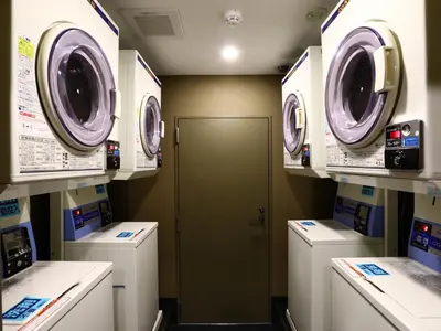 a laundry room with washing machines and a door at APA Hotel Yamanote Otsuka Ekimae Tower in Tokyo
