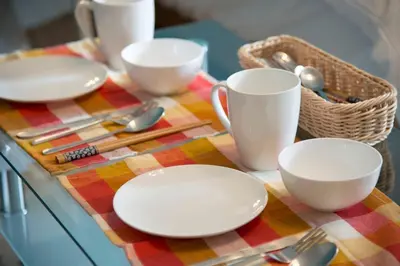 a table with white plates and spoons on a colorful table cloth at Roppongi Azabu Gorgeous Sea House in Tokyo