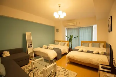 a bedroom with two beds and a mirror and a couch at Roppongi Azabu Gorgeous Sea House in Tokyo