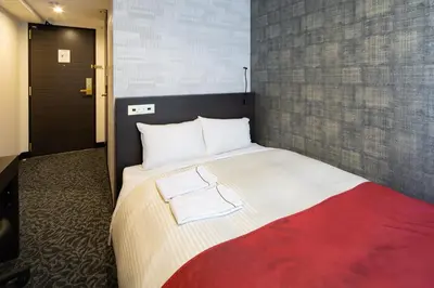 a bedroom with a bed with two towels on it at Ai Hotel Keikyu Kamata in Tokyo