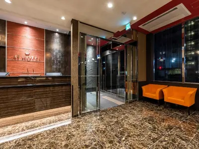 a lobby with an orange bench and a bar at Ai Hotel Keikyu Kamata in Tokyo