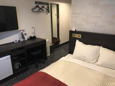 a hotel room with a bed and a desk and a television at Ai Hotel Keikyu Kamata in Tokyo