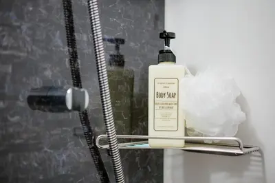 a bottle of soap sitting on a shelf in a bathroom at IKIDANE Residential Hotel Komagome in Tokyo