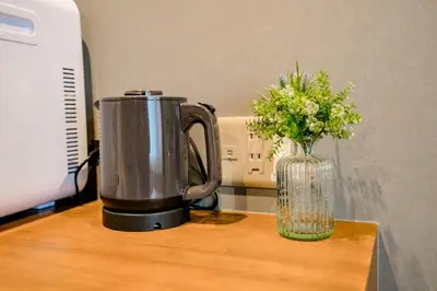 a blender and a vase of flowers on a table at IKIDANE Residential Hotel Komagome in Tokyo