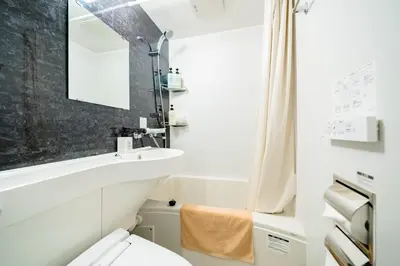 a bathroom with a sink and a toilet at IKIDANE Residential Hotel Komagome in Tokyo