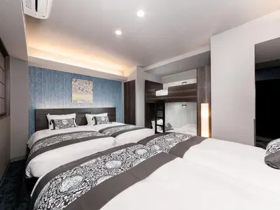 a bedroom with three beds and a blue wall at MIMARU Tokyo Ginza East in Tokyo