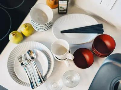a table with white plates and utensils on it at MIMARU Tokyo Ueno Okachimachi in Tokyo