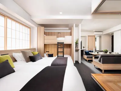 a bedroom with two white beds and a living room at MIMARU Tokyo Ueno Okachimachi in Tokyo