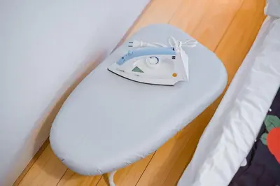 a white iron sitting on top of a bed at Bunkyo-ku Hakusan House in Tokyo