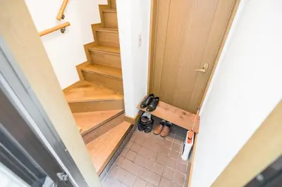 an overhead view of a door with shoes on the floor at Bunkyo-ku Hakusan House in Tokyo