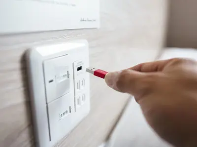 a person holding a cigarette in front of a lightswitch at Super Hotel Premier Akihabara in Tokyo