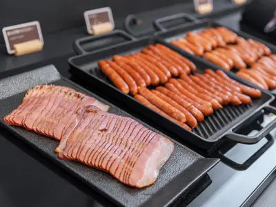 a bunch of hot dogs and sausages on a grill at Super Hotel Premier Akihabara in Tokyo